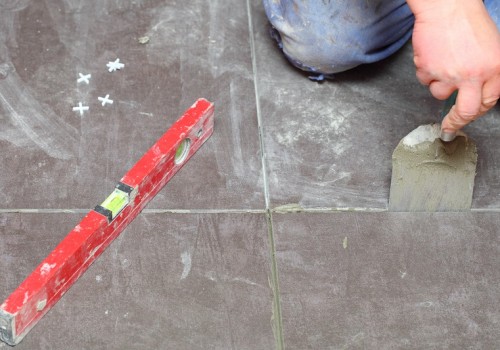 Man Construction worker is tiling at home, tile floor adhesive